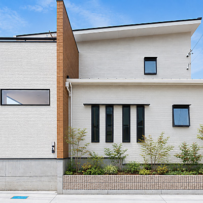 焼津市の注文住宅施工事例。白の外壁に木目のアクセント壁がスタイリッシュなモダン住宅
